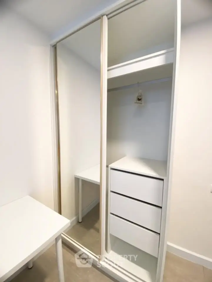 Spacious modern closet with sliding doors and built-in drawers in a bright room.