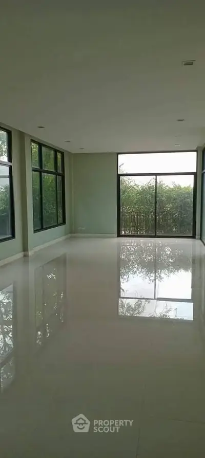Spacious empty room with large windows and glossy floor, perfect for customization.