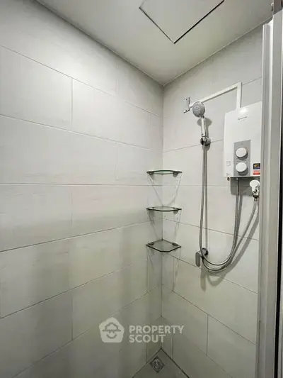 Modern bathroom shower with sleek tiles and glass shelves