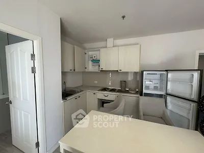 Compact kitchen with open fridge and modern appliances in cozy apartment