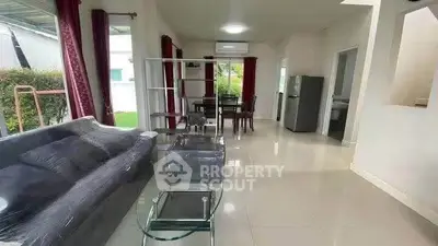 Spacious living room with modern furniture and garden view, perfect for family gatherings.