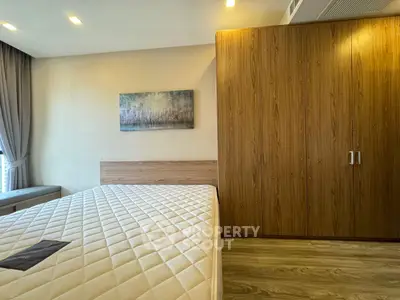 Modern bedroom with wooden wardrobe and large window for natural light