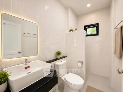Modern bathroom with sleek design, featuring a large mirror and elegant fixtures.
