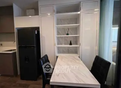 Modern kitchen with sleek black fridge and marble dining table