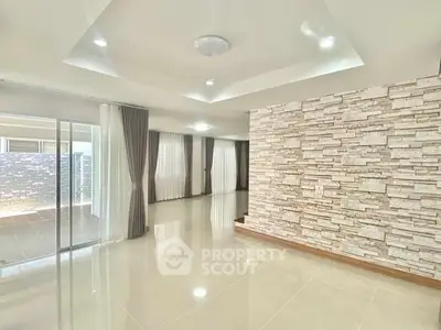 Spacious modern living room with stone accent wall and large windows