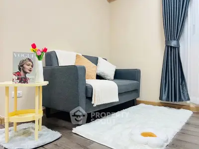 Cozy living room with modern sofa, stylish decor, and elegant curtains.