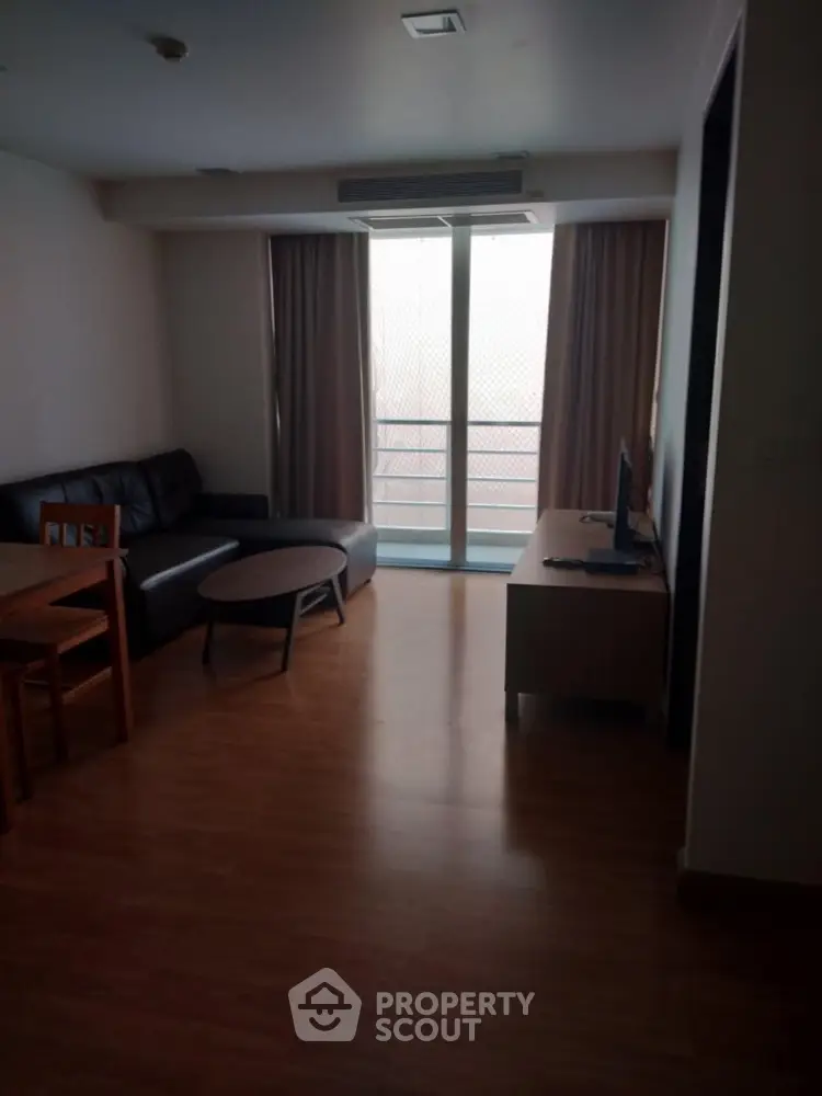 Cozy living room with modern furniture and balcony access in a stylish apartment.
