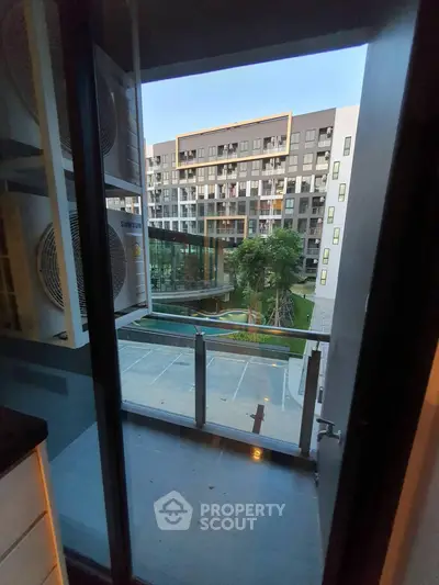Modern apartment balcony with view of contemporary building and lush greenery