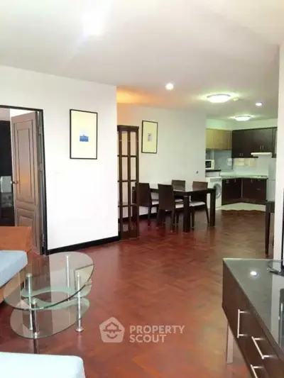 Spacious open-plan living room with dining area and modern kitchen in elegant apartment.