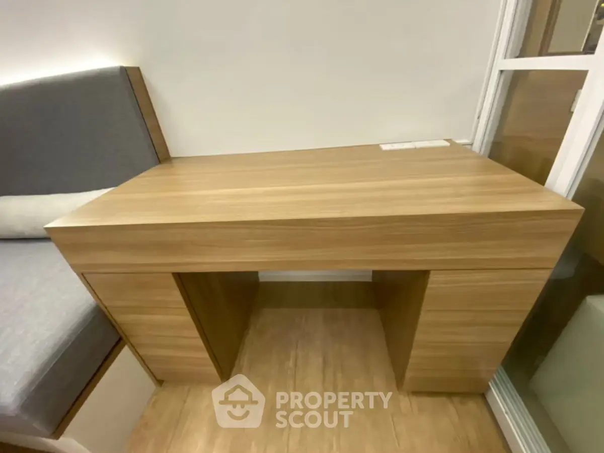 Modern wooden study desk with built-in seating in cozy interior space.