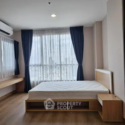 Modern bedroom with large windows and wooden flooring in a high-rise apartment.
