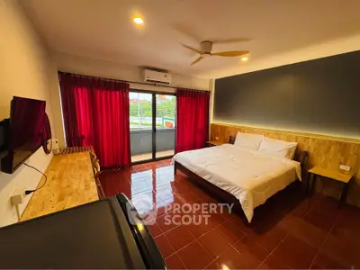 Spacious bedroom with modern decor and balcony access in a stylish apartment.