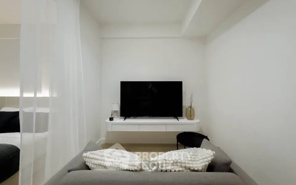 Modern living room with sleek TV setup and cozy sofa in minimalist design.