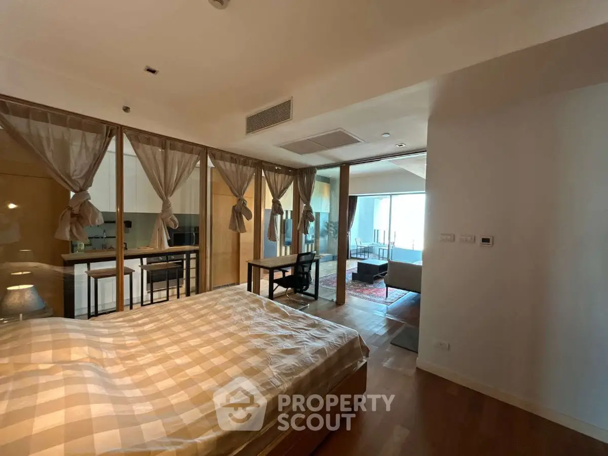 Spacious bedroom with elegant decor and open view to living area