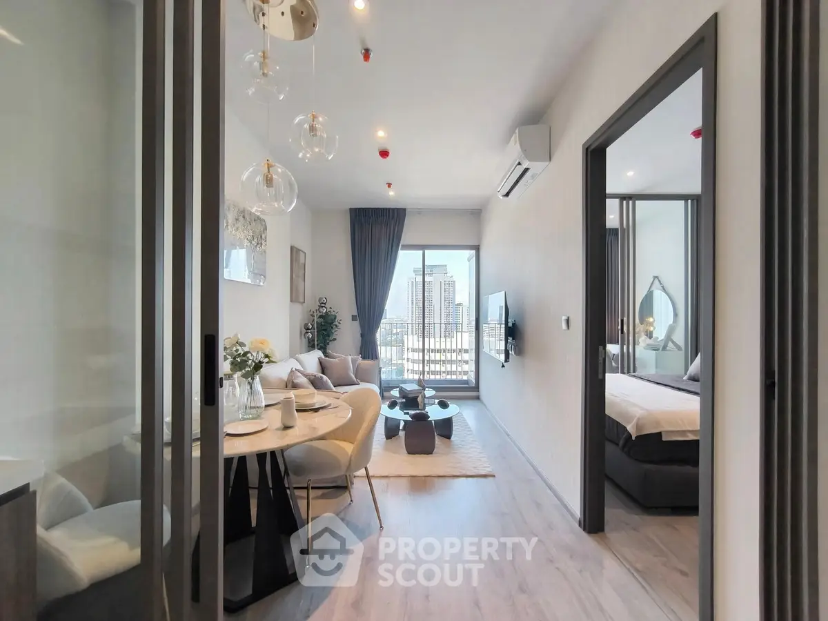 Modern apartment interior with open living room and bedroom, featuring stylish decor and city view.