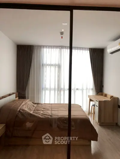 Modern bedroom with large window and wooden furniture, featuring a cozy bed and study desk.
