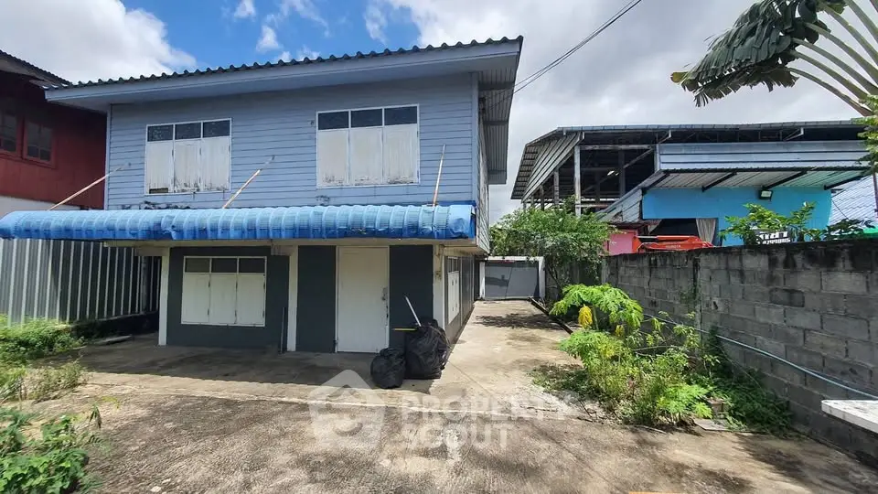 Charming two-story house with spacious driveway and lush greenery