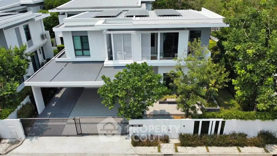 Modern two-story house with sleek design and lush greenery in a serene neighborhood.