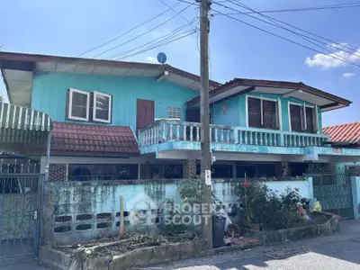 Charming blue two-story house with balcony and garden in a serene neighborhood.