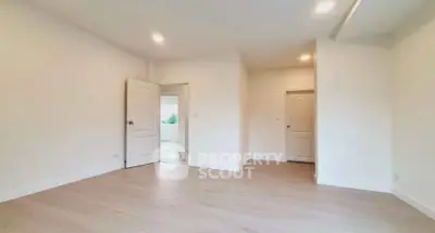 Spacious empty room with wooden flooring and white walls, ideal for customization.