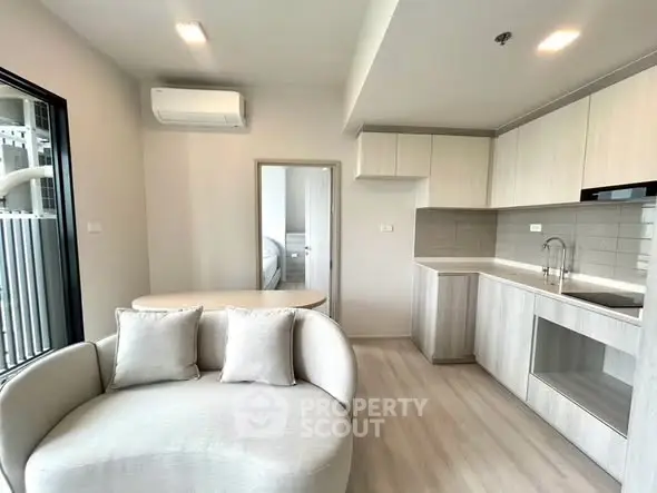 Modern open-plan living room with sleek kitchen and cozy seating area