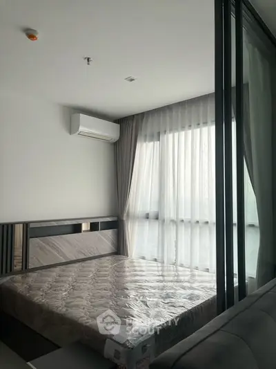Modern bedroom with large window and air conditioning in a stylish apartment.