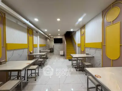 Modern dining area with sleek tables and vibrant yellow accents