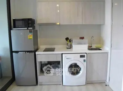 Modern kitchen with sleek appliances and compact design, featuring a washing machine and microwave.