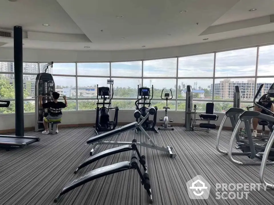 Spacious gym with modern equipment and panoramic city views