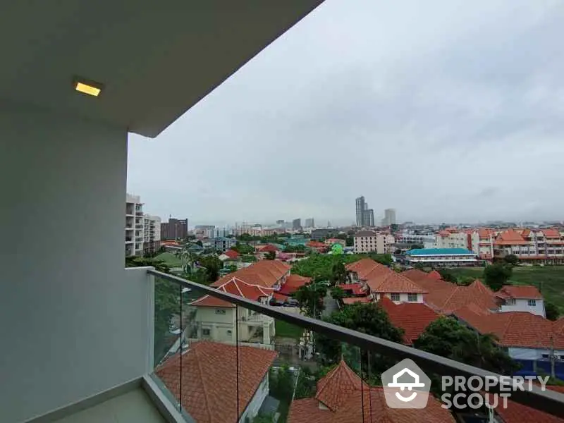 Stunning balcony view overlooking vibrant cityscape with red-roofed houses and skyline.