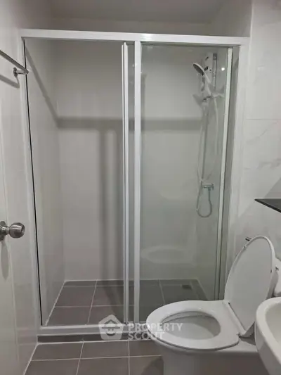 Modern bathroom with glass shower enclosure and sleek fixtures.
