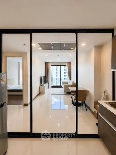 Modern apartment interior with open layout, featuring a cozy living room and dining area with large windows.