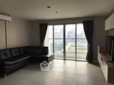 Spacious modern living room with city view and sleek black sofa