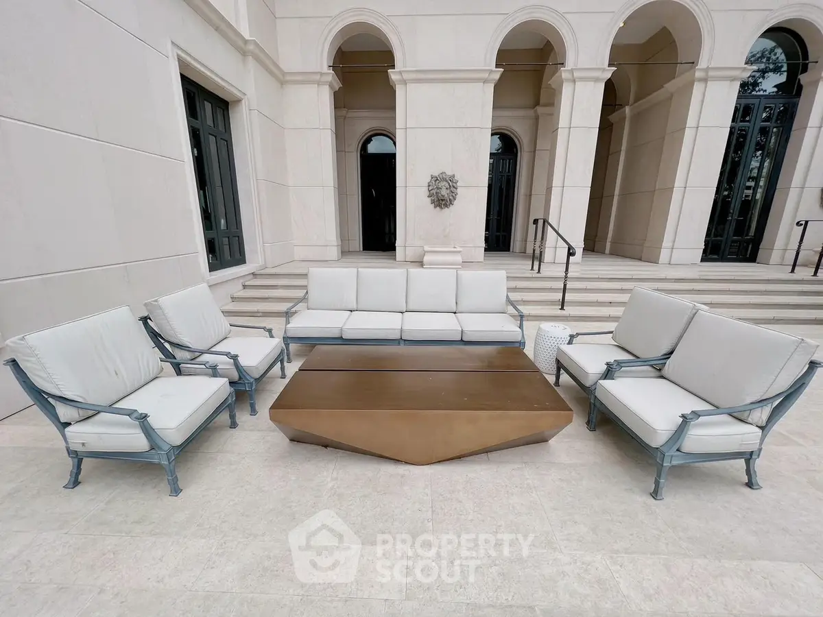 Luxurious outdoor seating area with elegant furniture in a grand architectural setting.