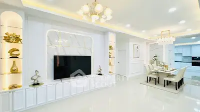 Luxurious open-plan living and dining area with elegant decor and modern lighting.