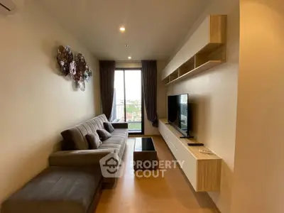 Modern living room with stylish decor and large window offering natural light