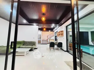 Luxurious modern living room with pool view, featuring sleek design and elegant furnishings.