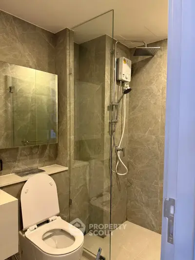 Modern bathroom with glass shower and sleek fixtures in a contemporary apartment.