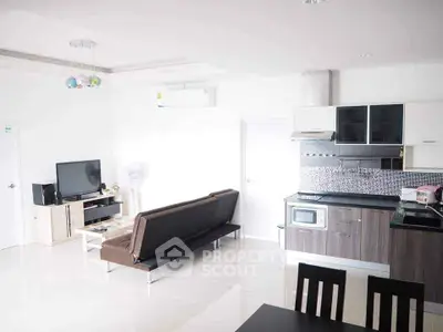 Modern open-plan living room and kitchen with sleek furniture and appliances.