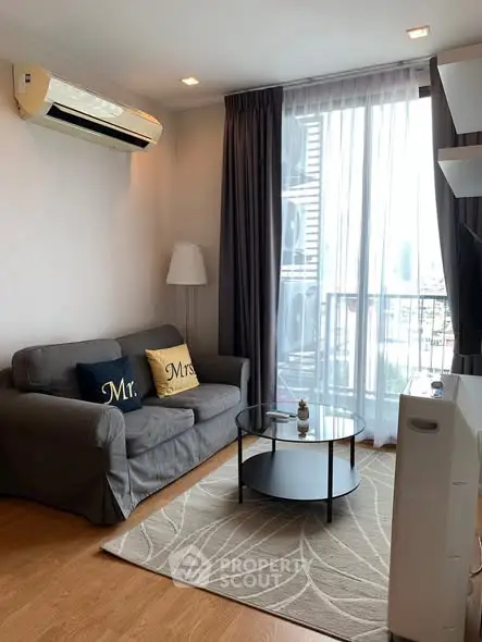 Charming living room with cozy sofa and large window in modern apartment.