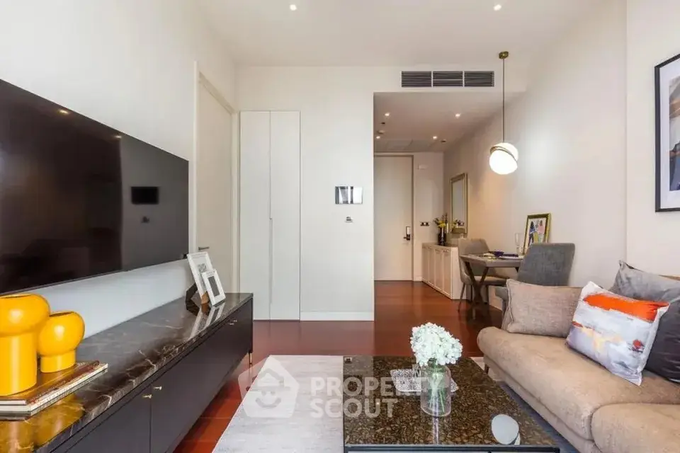 Modern living room with sleek furniture and large TV, perfect for relaxation and entertainment.