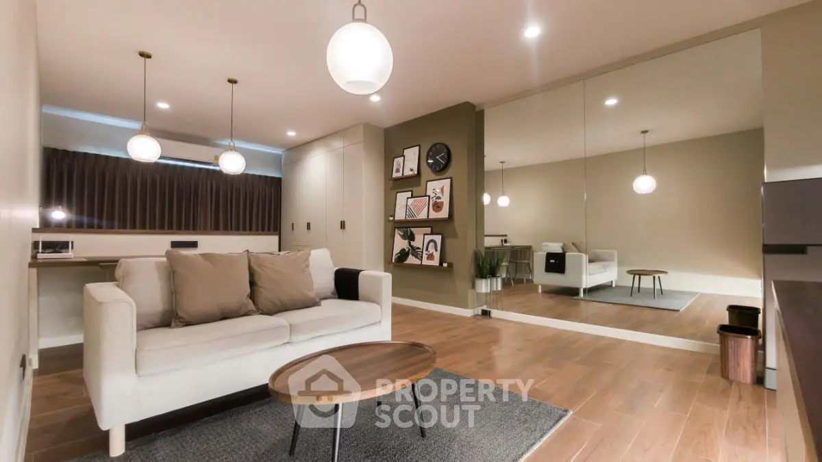 Modern living room with stylish decor and large mirror wall