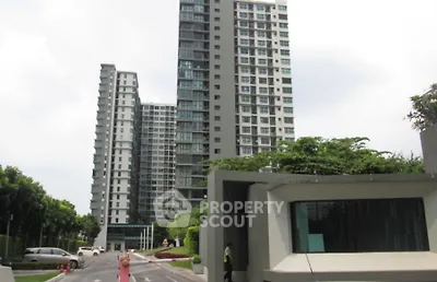 Modern high-rise residential buildings with lush greenery and secure entrance.