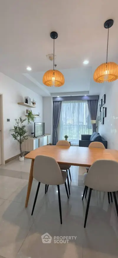 Modern living room with elegant dining area and large window view, featuring stylish lighting and decor.