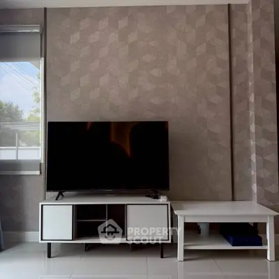 Modern living room with stylish TV stand and geometric wallpaper, perfect for contemporary home decor.