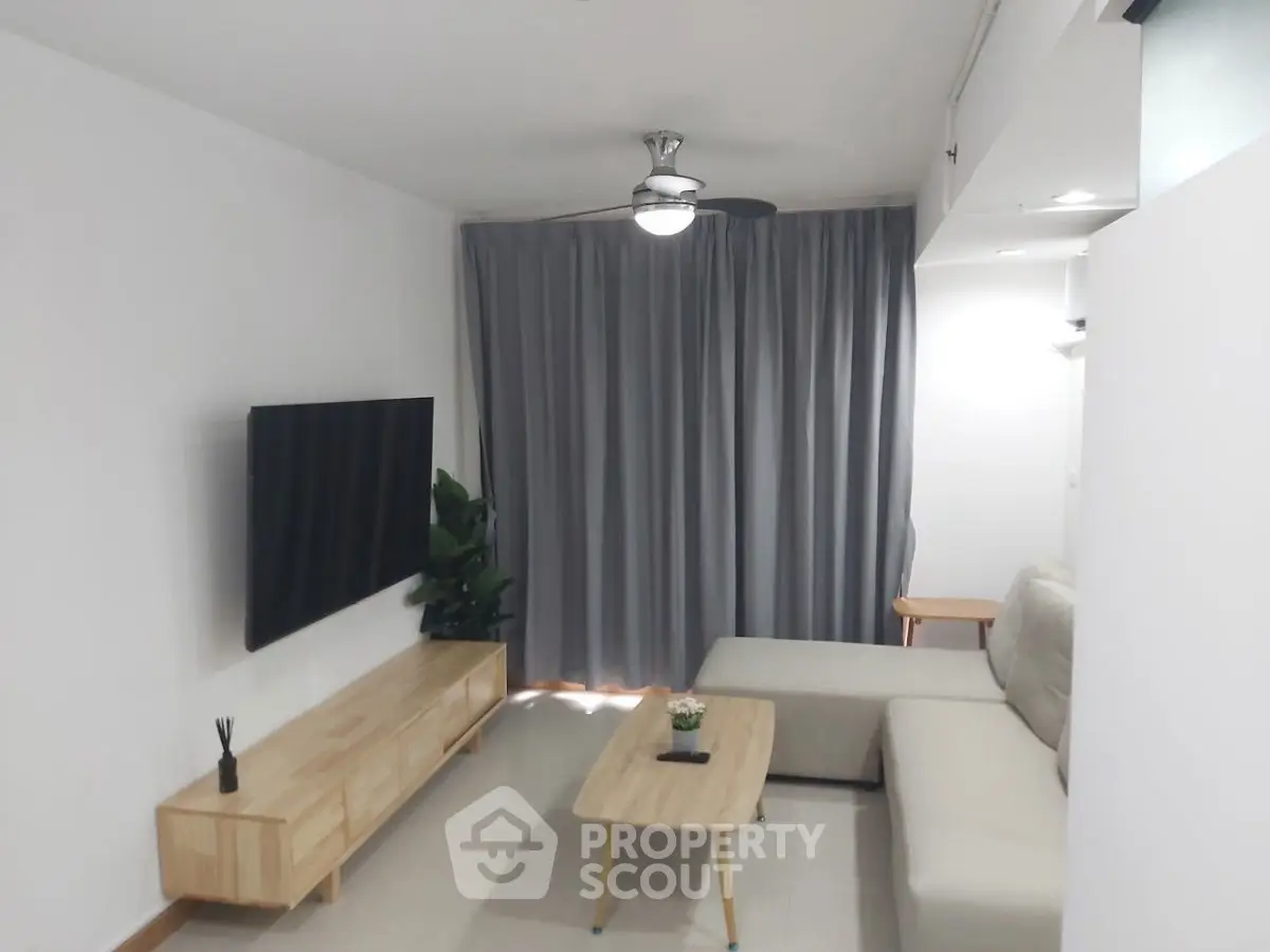 Modern living room with sleek furniture and wall-mounted TV