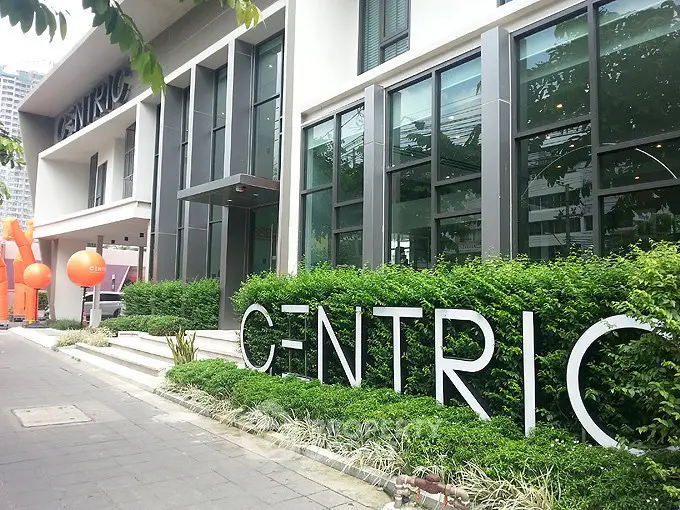 Modern building exterior with lush greenery and stylish signage