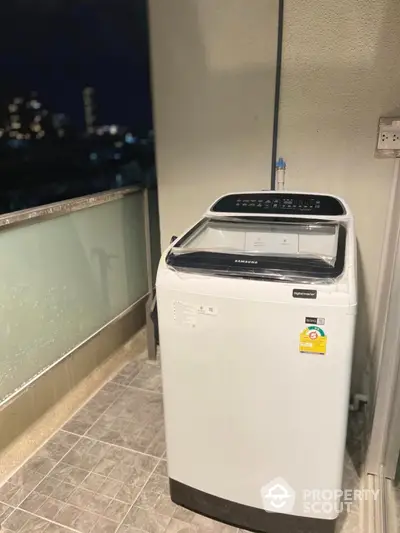 Modern washing machine on balcony with city night view