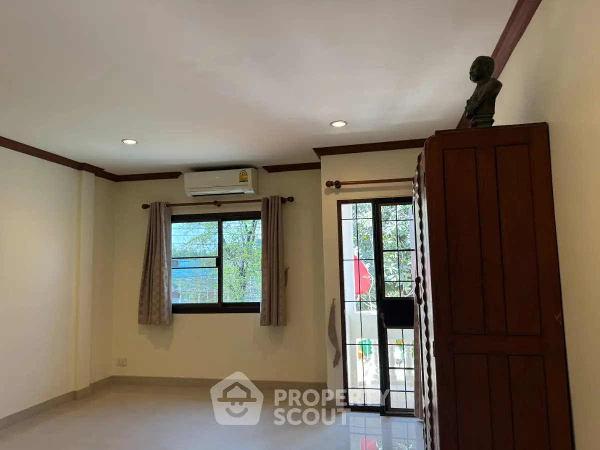 Spacious living room with natural light and balcony access in modern apartment.