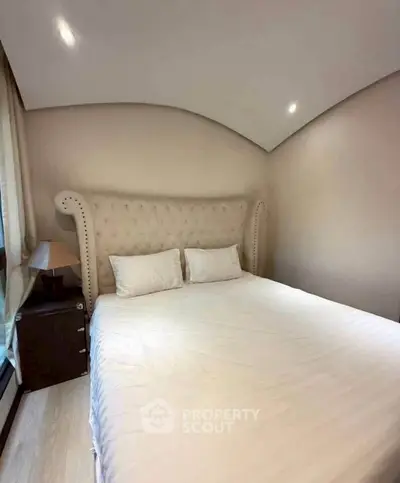Cozy bedroom with elegant tufted headboard and soft lighting, perfect for relaxation.